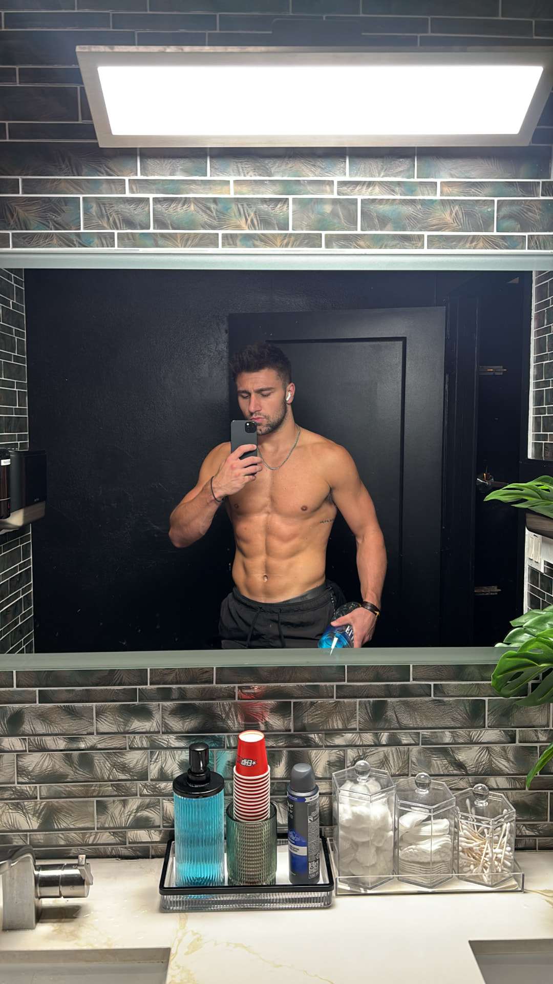 Brandon Neshat documenting his fitness progress in a bathroom mirror